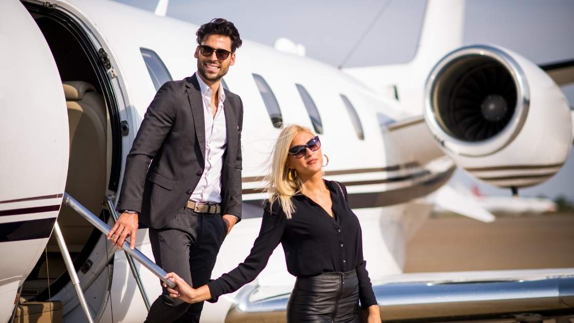 picture of wealthy couple getting off private jet